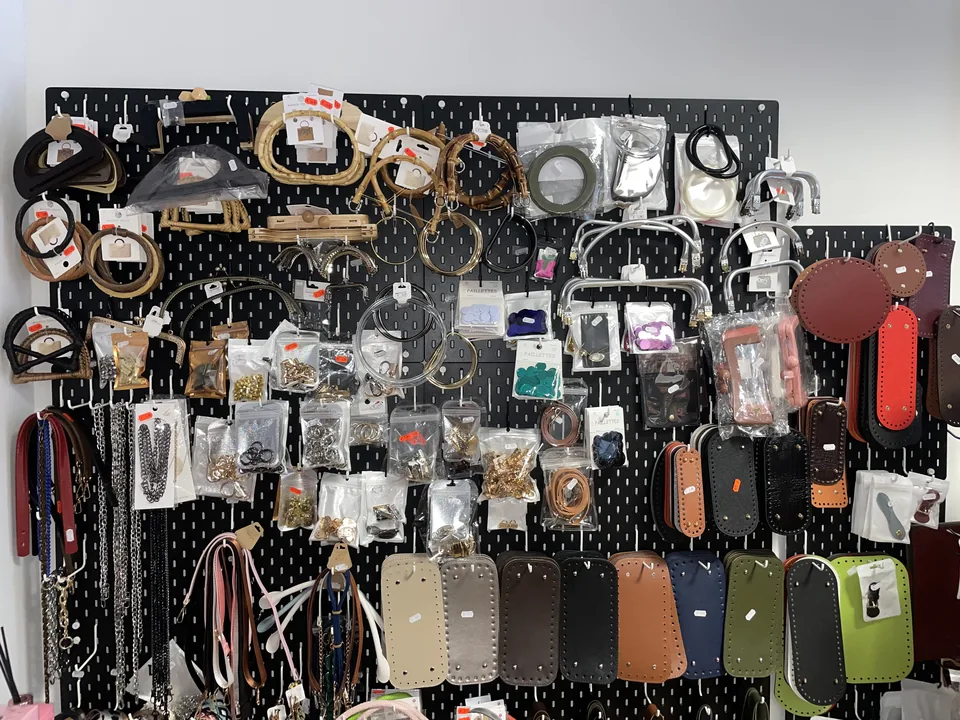 Parete con manici, tracolle, cordini e accessori per borse